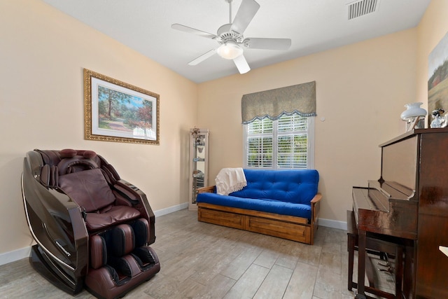 sitting room with visible vents, a ceiling fan, baseboards, and wood finished floors