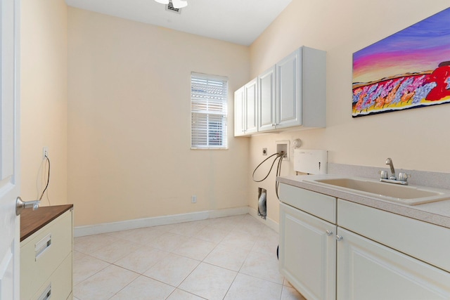 clothes washing area featuring electric dryer hookup, washer hookup, a sink, cabinet space, and light tile patterned flooring