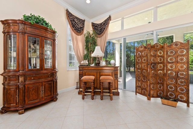 sitting room featuring light tile patterned floors, baseboards, and ornamental molding