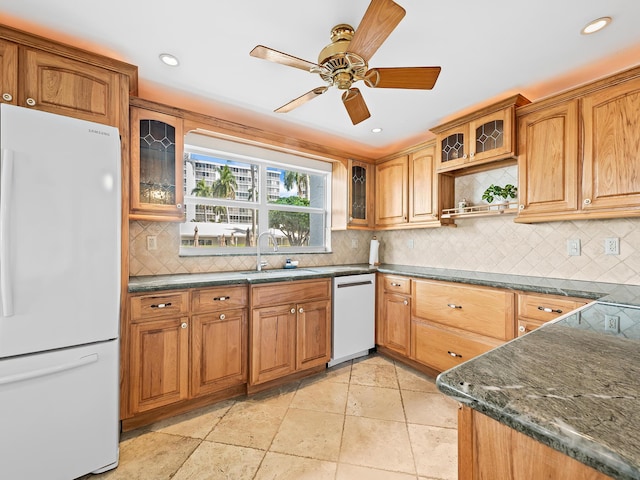 kitchen with a sink, glass insert cabinets, white appliances, and recessed lighting