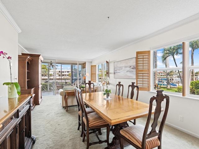 dining room with ornamental molding, baseboards, and light carpet