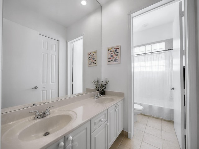 full bath with tile patterned flooring, double vanity, toilet, and a sink