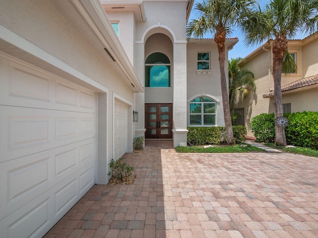 doorway to property with driveway and stucco siding
