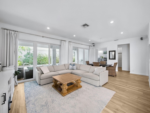 living area featuring visible vents, recessed lighting, light wood-type flooring, and baseboards