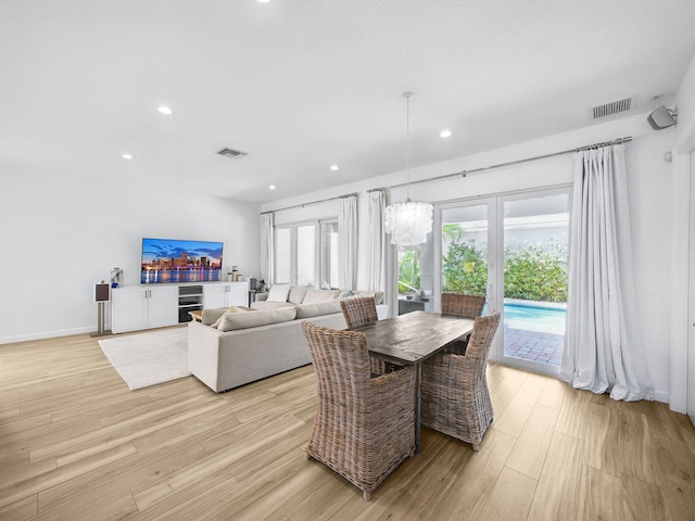 dining area with light wood-type flooring, visible vents, an inviting chandelier, and recessed lighting