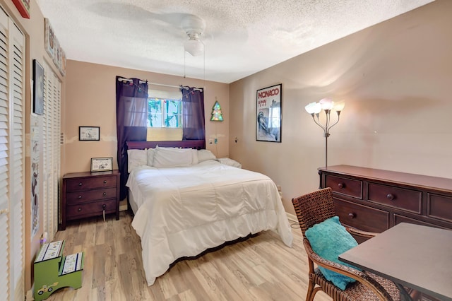 bedroom featuring ceiling fan, a textured ceiling, and light wood-style flooring