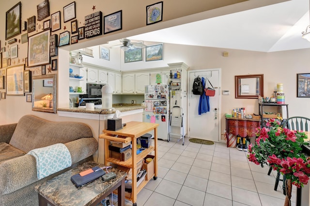 living room with vaulted ceiling, light tile patterned floors, and ceiling fan