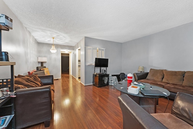 living area with a textured ceiling, baseboards, and wood-type flooring