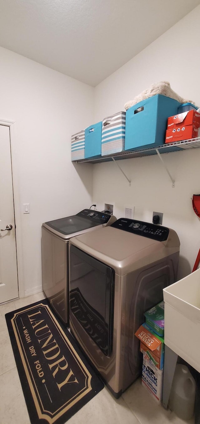 laundry room featuring laundry area, washing machine and dryer, and a sink