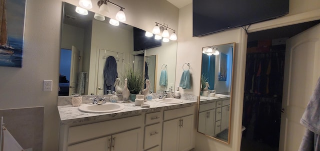 full bath featuring double vanity, visible vents, and a sink