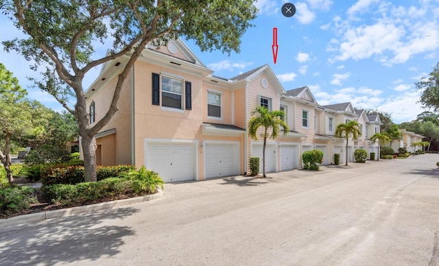 826 Dakota Dr Unit 105, Jupiter, FL 33458 - view of property featuring an attached garage, a residential view, and stucco siding