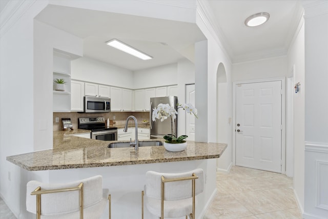 826 Dakota Dr Unit 105, Jupiter, FL 33458 - kitchen featuring appliances with stainless steel finishes, a sink, light stone countertops, a peninsula, and open shelves