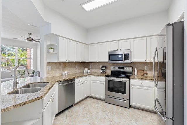 826 Dakota Dr Unit 105, Jupiter, FL 33458 - kitchen featuring stainless steel appliances, a sink, open shelves, backsplash, and white cabinets