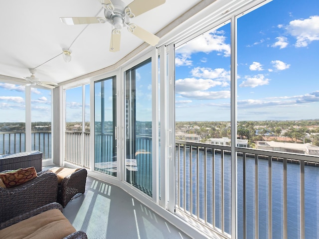 sunroom with a water view and ceiling fan