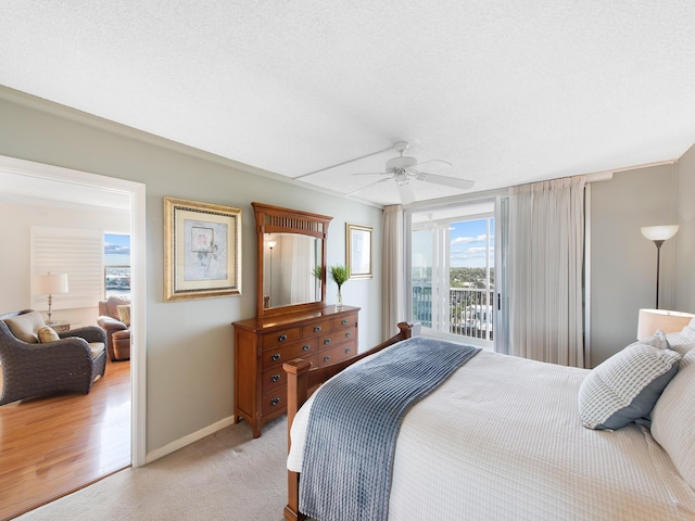 bedroom with light carpet, a textured ceiling, a ceiling fan, and baseboards