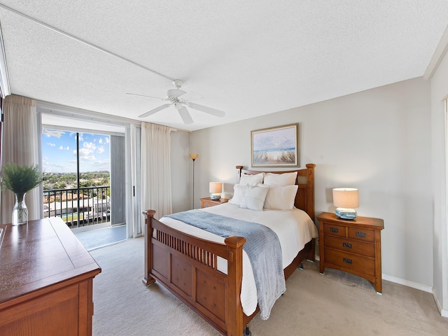 bedroom featuring light carpet, a textured ceiling, ceiling fan, and access to outside