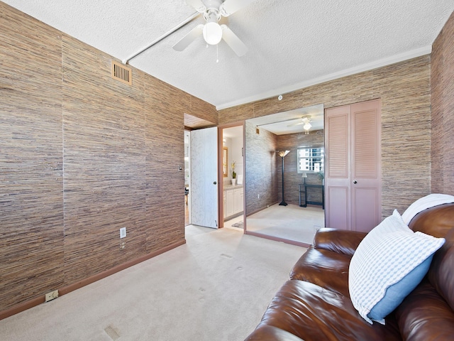 sitting room featuring carpet flooring, a textured ceiling, and a ceiling fan