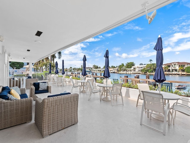 view of patio with outdoor dining area and a water view
