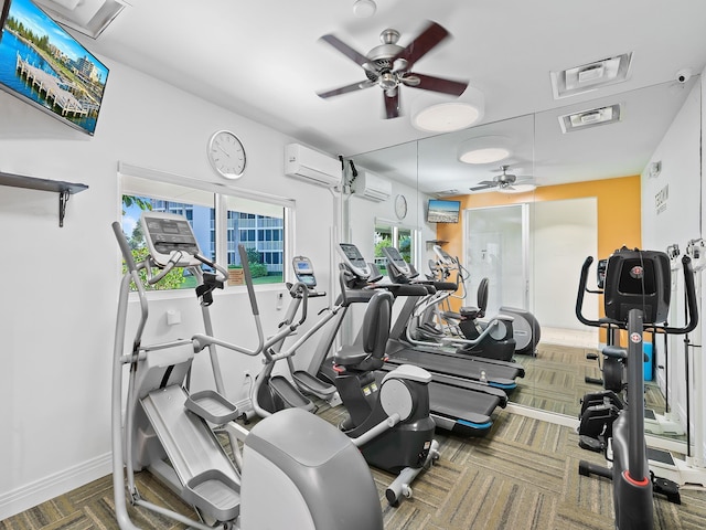 exercise room featuring visible vents, baseboards, a ceiling fan, and a wall unit AC