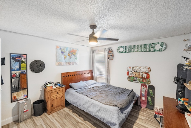 bedroom with light wood finished floors, a textured ceiling, and a ceiling fan