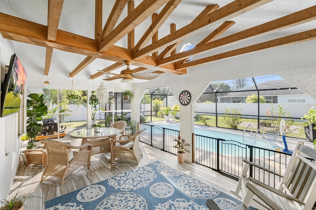 sunroom / solarium with vaulted ceiling with beams and a ceiling fan