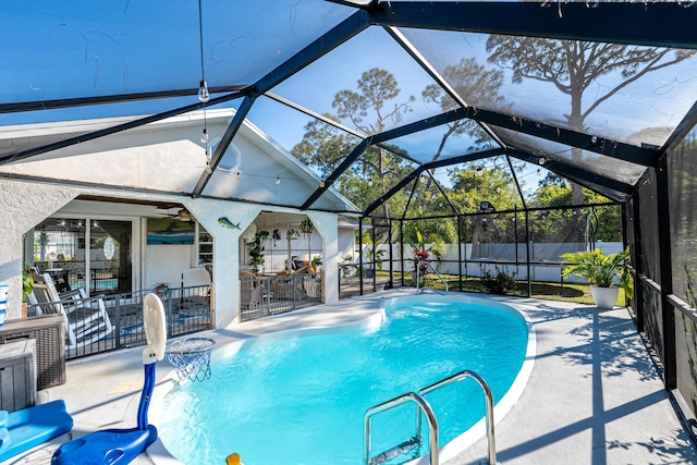 view of swimming pool featuring glass enclosure, a patio, a fenced backyard, and a fenced in pool