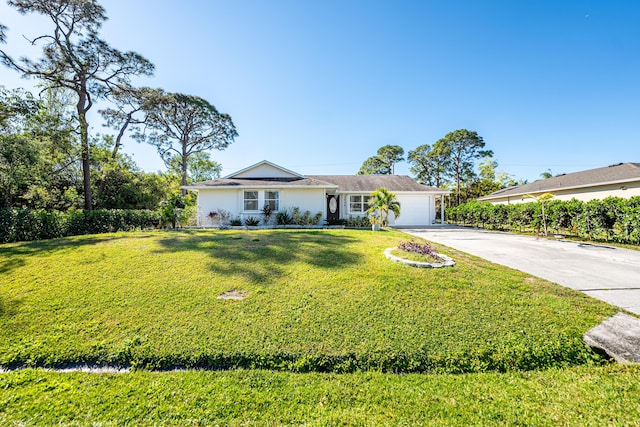 ranch-style home featuring concrete driveway, an attached garage, and a front lawn