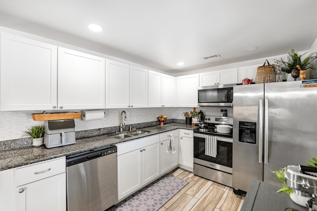 kitchen featuring visible vents, stainless steel appliances, decorative backsplash, and a sink