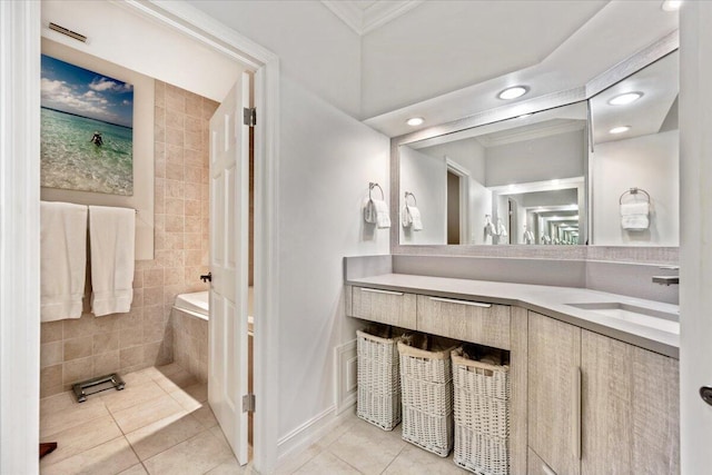 bathroom with tiled bath, crown molding, tile patterned flooring, baseboards, and vanity