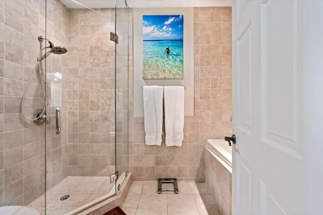 full bathroom with a stall shower and tiled tub