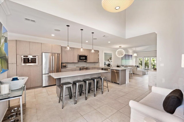 kitchen featuring visible vents, open floor plan, stainless steel appliances, a peninsula, and light countertops