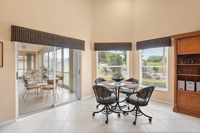 dining room featuring a high ceiling, light tile patterned floors, and baseboards