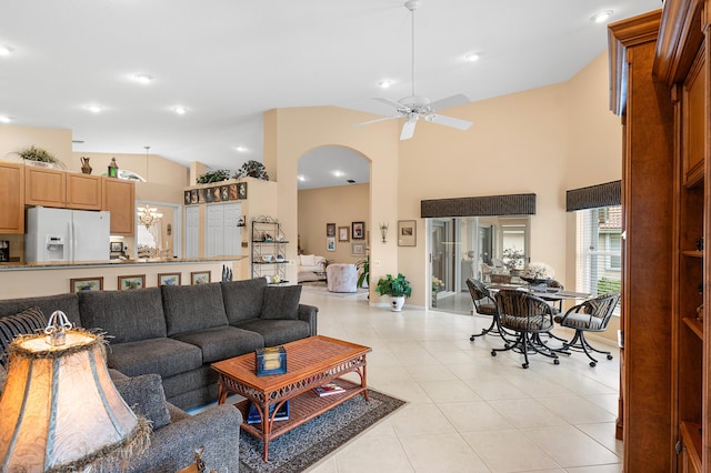 living room with light tile patterned floors, arched walkways, high vaulted ceiling, and ceiling fan