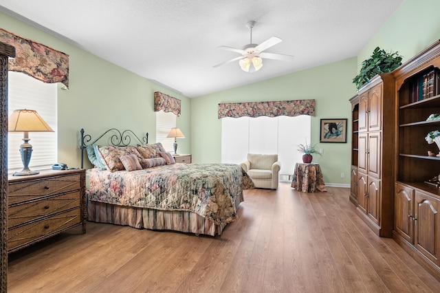 bedroom with multiple windows, light wood-type flooring, and vaulted ceiling