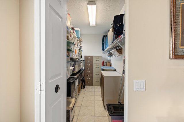 laundry area featuring light tile patterned floors, a textured ceiling, and laundry area