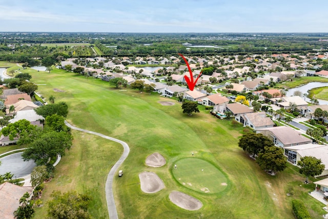 drone / aerial view featuring a residential view, golf course view, and a water view