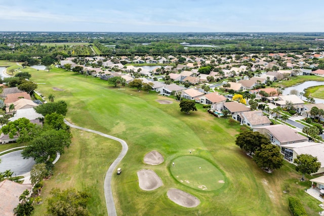 drone / aerial view featuring view of golf course, a residential view, and a water view