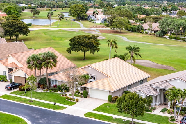 aerial view with golf course view, a residential view, and a water view