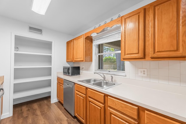 kitchen with visible vents, a sink, stainless steel appliances, light countertops, and dark wood-type flooring