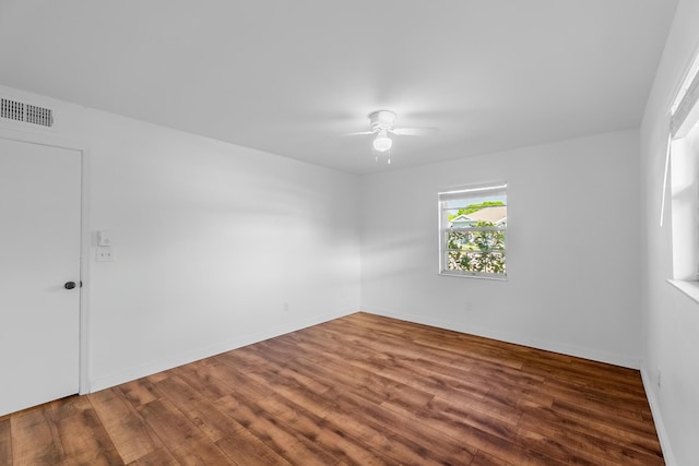 spare room with visible vents, baseboards, wood finished floors, and a ceiling fan