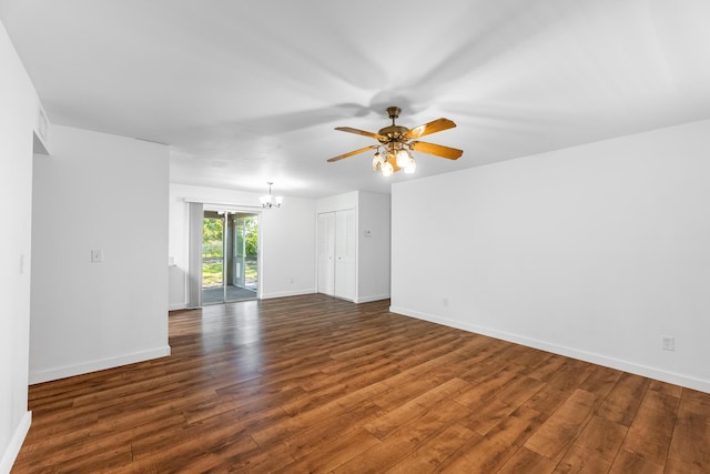 empty room featuring ceiling fan with notable chandelier, wood finished floors, and baseboards