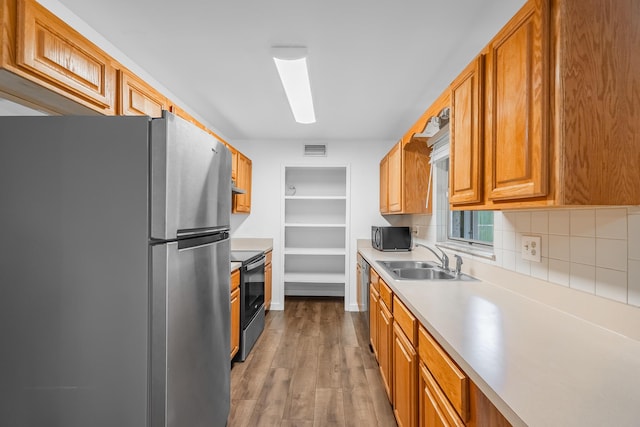kitchen with visible vents, dark wood finished floors, light countertops, appliances with stainless steel finishes, and a sink