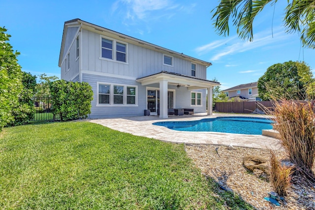 back of house featuring a fenced backyard, a patio area, board and batten siding, and a yard