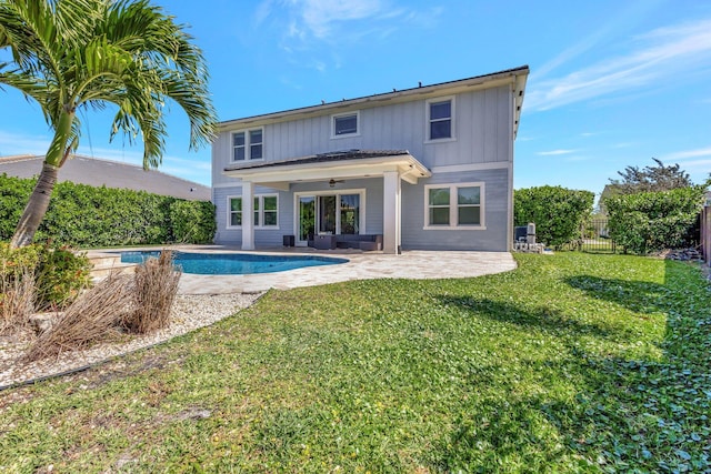 back of house with ceiling fan, fence, a yard, a patio area, and an outdoor pool