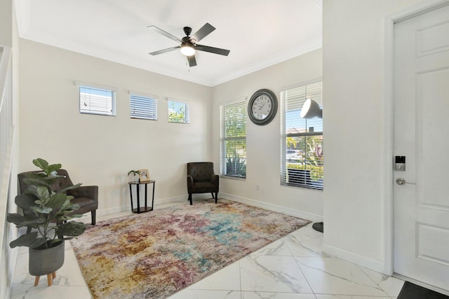 living area with marble finish floor, ceiling fan, baseboards, and ornamental molding