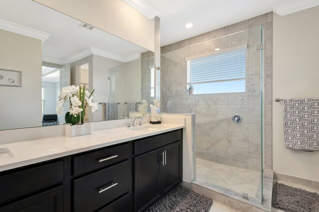 full bath with visible vents, crown molding, double vanity, a tile shower, and a sink