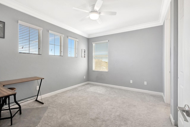 carpeted empty room with baseboards, crown molding, and a ceiling fan