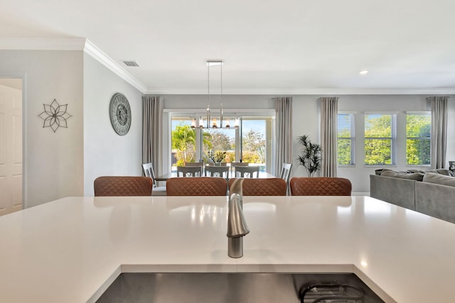 dining space with visible vents, an inviting chandelier, and ornamental molding