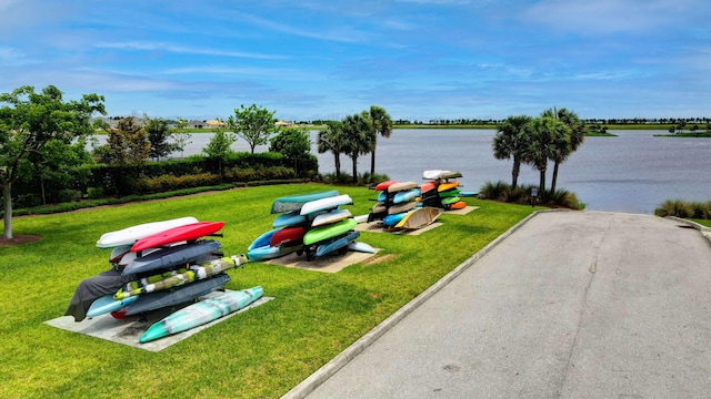 view of home's community featuring a lawn and a water view