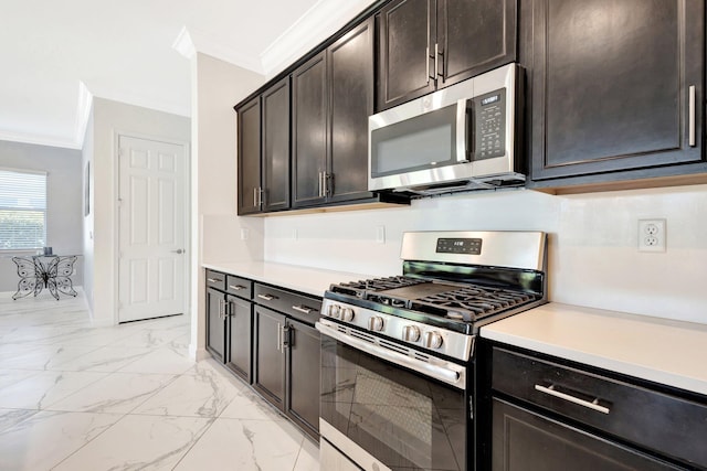 kitchen with light countertops, marble finish floor, appliances with stainless steel finishes, and ornamental molding